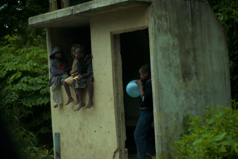 Children waiting next to road for passing tourists to ask for sweets.