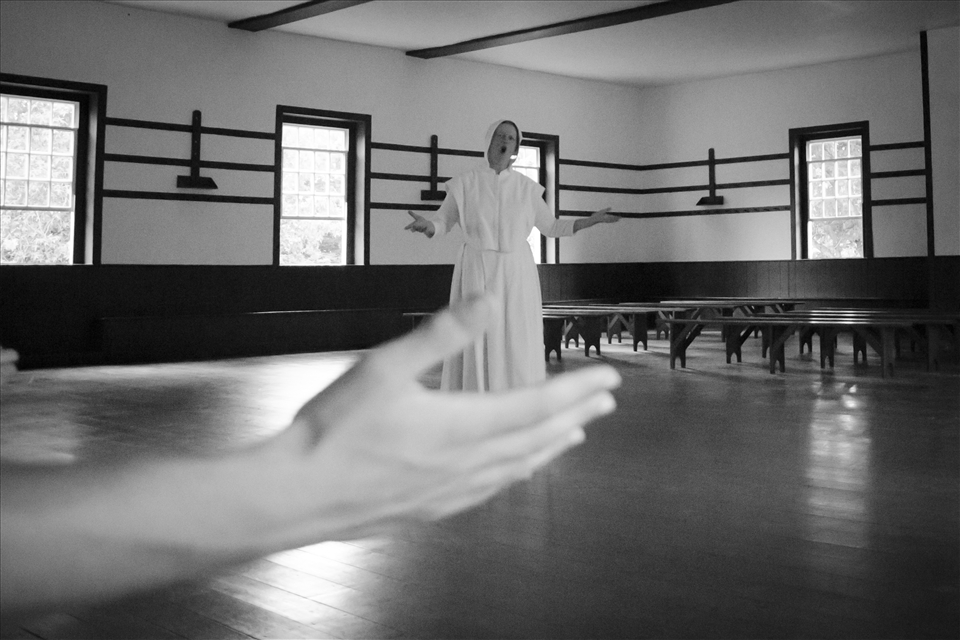 A Shaker woman sings a hymn at Shakertown of Pleasant Hill.