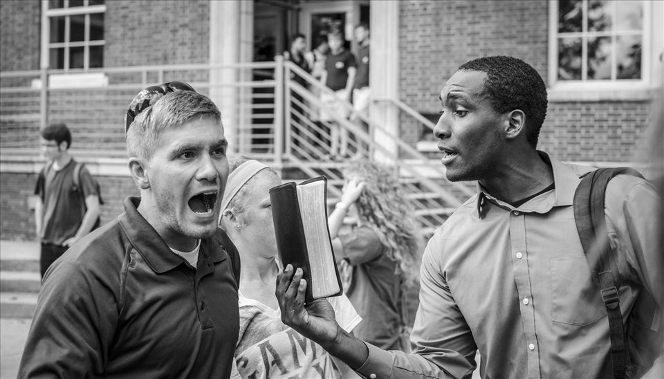 A college student with a Bible argues with an evangelist.