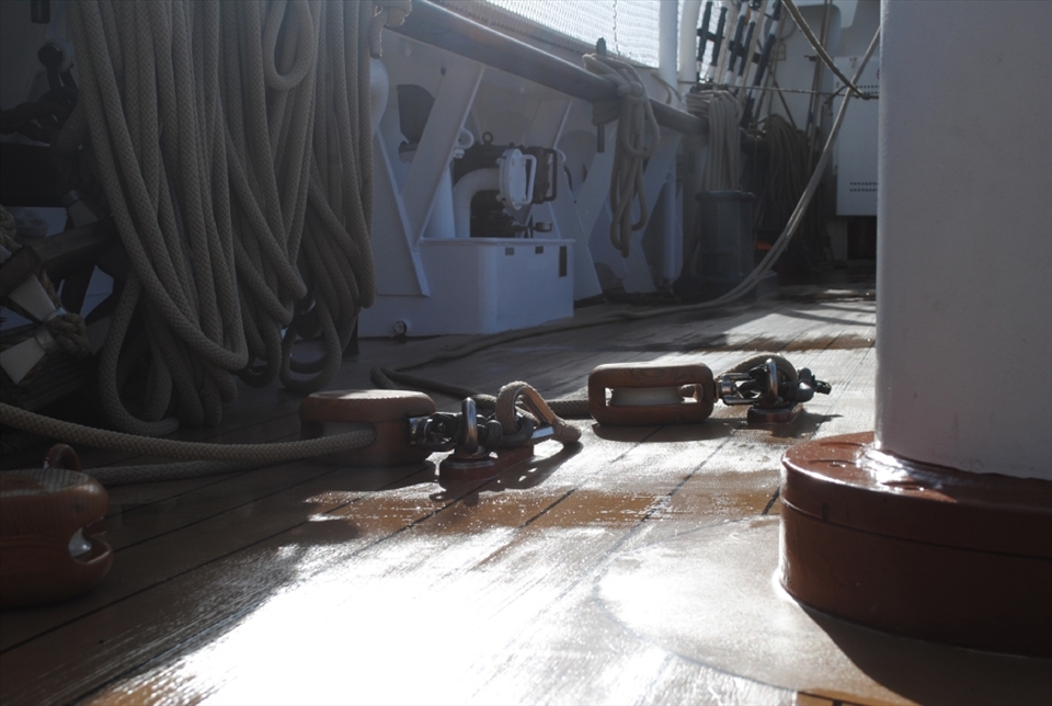 After the storm. The deck was certainly well washed, though mostly by large waves rather than by the crew. Here we see the first morning of sunshine after the storm reflecting an empty deck, with most of the crew still below deck. 