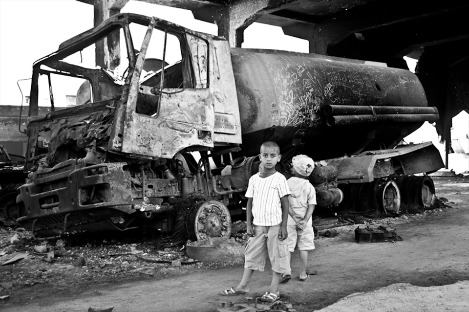 Two young libyan boys gaze upon the aftermath of destruction.