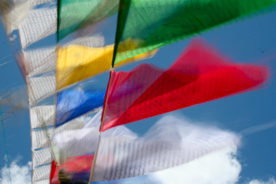 Prayer flags fluttering in the wind at Kunzum La, the gateway to the valley. The sutras(prayers) are released to the wind to purify the air and appease the gods. The colours represent the elements: Space(Blue), Wind(White), Fire(Red),  Water(Green) and Earth(Yellow), the balance of which is said to promote peace, strength, wisdom and compassion.