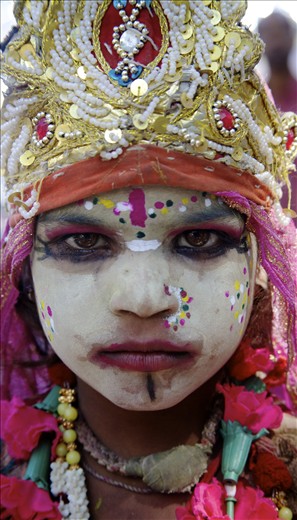 A young girl, decorated for the festival, turns serious for her portrait