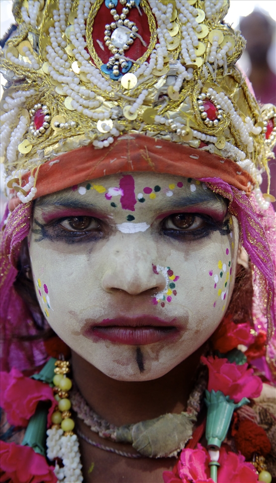 A young girl, decorated for the festival, turns serious for her portrait