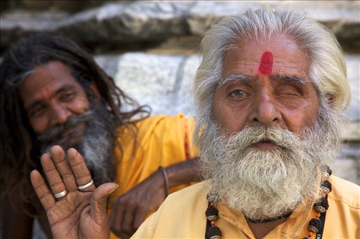 A disfigured holy man greets visitors along with his happy friend