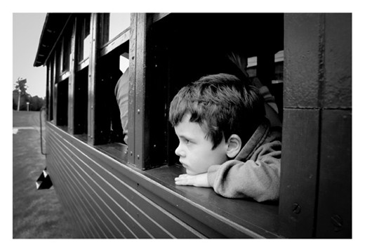 Little boy thinking while riding and old train. Argentina