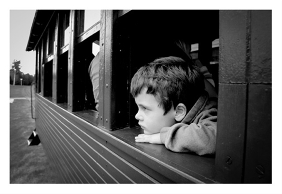 Little boy thinking while riding and old train. Argentina