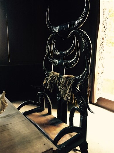 Chair made of black horns, at a table set with crocodile skins and bones. Said to represent worldly desires and mortality. 