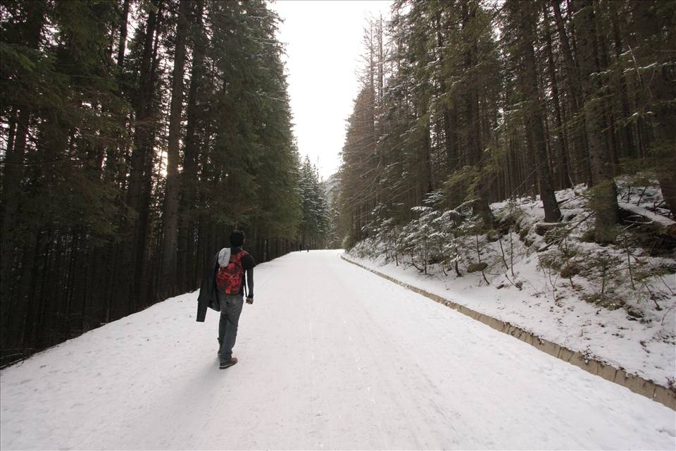 A man walking on a snowy road to Morskie Oko.