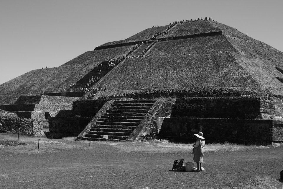 The third largest pyramid in the world known as the Pyramid of the Sun, which is located on the avenue of death in Teotihuacan near Mexico City. We can see  a steady stream of visitors passing through, as a lonely vendor waits for customers.