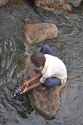 Meet Peter, our tour guide. Peter is an 11 year old boy, who spends his days taking the tourists on a hike from the top of the falls to the bottom. This is their 7 member family's only source of income. In this photo, Peter washes a cap that one of the American tourists dropped on their hike to keep for himself because he tells us that other than the clothes he has on his back, he has 2 other pairs.: by dishaparekh, Views[495]
