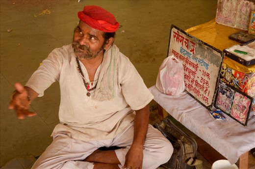 The ear cleaner.
Another traditional trade in India is the ear cleaner. Usually seen walking along roads wielding a box with “Ear cleaner” written on it, they can also be found sitting offering their services in public places. It is a low-paid job and most ear cleaners live in poverty unless they are good at swindling unknowing tourists for extra rupees. In the photo: this ear cleaner lives and works on the bus stand in Agra, Uttar Pradesh. The inscription on the certificate that he showed me reads: “Certified that Shri Ramesh Chand, Jagner Road, Agra, ear cleaner at Idgah Bus Station has been working for about 15 years. He is a good worker”; signature; stamp.