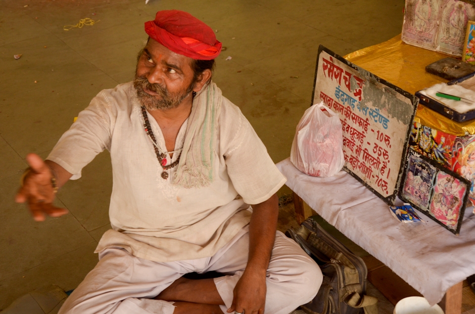 The ear cleaner.
Another traditional trade in India is the ear cleaner. Usually seen walking along roads wielding a box with “Ear cleaner” written on it, they can also be found sitting offering their services in public places. It is a low-paid job and most ear cleaners live in poverty unless they are good at swindling unknowing tourists for extra rupees. In the photo: this ear cleaner lives and works on the bus stand in Agra, Uttar Pradesh. The inscription on the certificate that he showed me reads: “Certified that Shri Ramesh Chand, Jagner Road, Agra, ear cleaner at Idgah Bus Station has been working for about 15 years. He is a good worker”; signature; stamp.