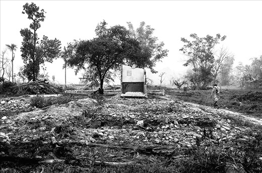  Her neighbour walks past the broken debris of a house, testimony to mob fury when a demographical movement went wrong and turned communal in nature. On July, 20th, 2012, major ethnic clashes triggered across the region, resulting in the form of riots, killing 71 people across 400 villages and 400,000 people taking refugee across 300 relief camps. 