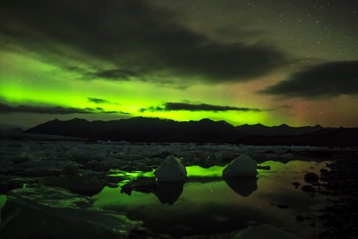 the still water caputres reflections of the aurora.  In the darkness we listen to the glacier break apart in the distance