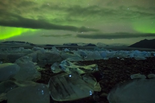 we made our way along the shore of the lagoon in pitch dark.  the aurora flickered over our heads illuminating the sky witha brilliant emerald while the the glacier ice captures reflections of starlite
