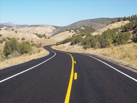 After ten days of driving, I reached the destination of my road trip. I took this photo to represent the beginning of my journey to and up the West Coast of the United States. The freshly paved road contrasts the tones of the sky and terrain.  I traveled on many roads, but had to stop for this one.  Shot with my Kodak Easyshare c195.