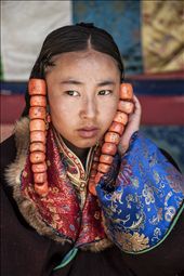 A young girl supports the coral beads from pulling on her hair as she waits to parade, for the best part of three days, in the Lurol Festival.: by doss, Views[1071]