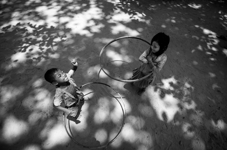 After having hula hoops donated to Stepping Stones School a young boy tries as hard as he can to master the art of hula hooping while a young girl who picked it up naturally looks on in disgust.