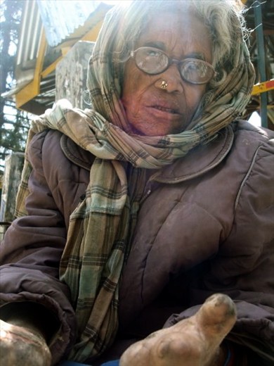 An old women sits on the street at the foot of the people passing...in their eyes she is of cast...an untouchable, a begger, a leper...