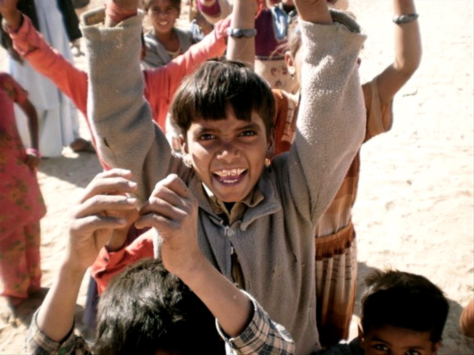 In the barren desert of Rajasthan out of the dust like a mirage emerges a gaggle of bare footed children with wide smiles and glittering eyes...
