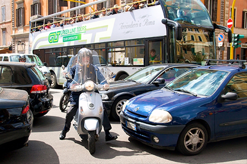 Motorcyclist sneaks through the cars as central Rome comes to a standstill as hoards of people make there way to the Vatican to hear the Pope's Mass on Easter Sunday