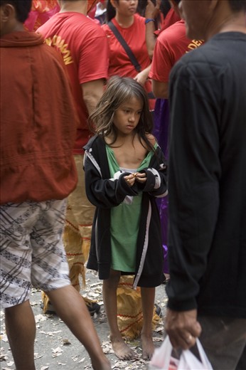 a sad girl that didnt get a chance to catch candies thrown by store owners in the chinese new year festival