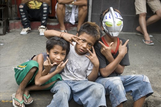 a group of children posing happily in the sidelines while watching several lion and dragon dance performance