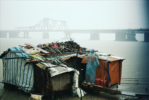 The period in which he feels the most insecure is from July to September every year as storms and floods strike frequently. In this storm, he alone struggle to protect his house from pushed away by the water.