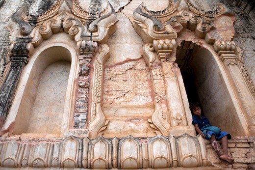 A capital in ruins: a local rests in an alcove of the crumbling ruins of one of the many pagodas in Inwa.