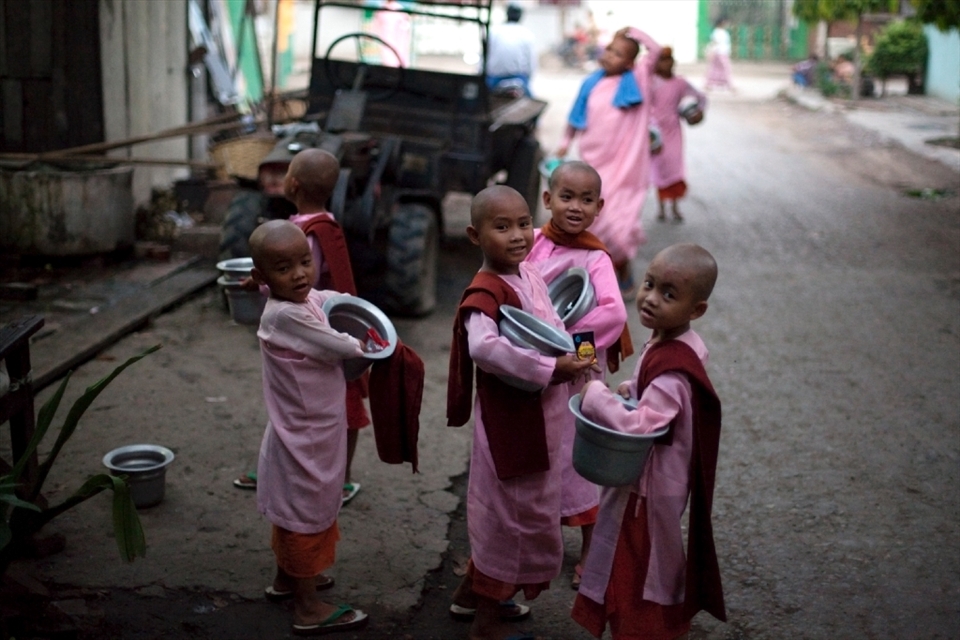 Morning alms: young novice Buddhist nuns in the pre-dawn light about to leave their monastery on their daily walk to collect alms from locals.
