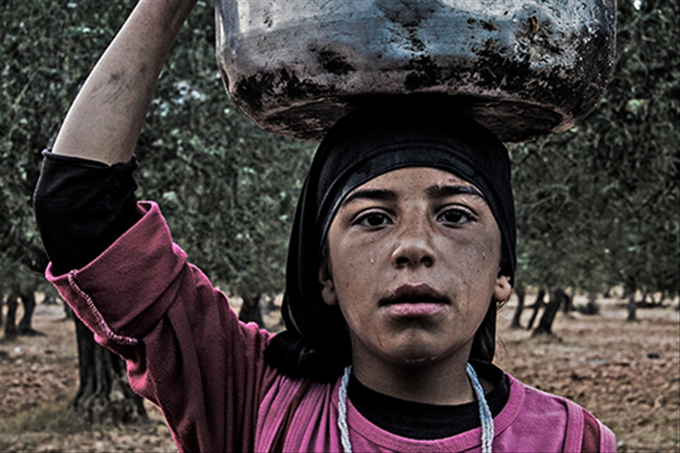 A YOUNG GIRL putting on her head a Cooking pot filled by wa PUTTING ON HER HEAD 