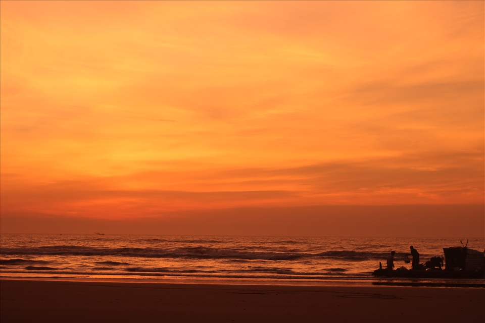 The first fishing boat to return after a long night on the sea at a quiet beach.
