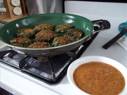 Spinach lentil patties beside a bowl of plum-date sauce.