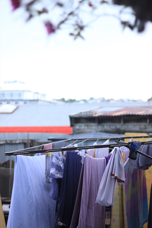 Clothes are left hanging to be dried in the rainy day at the hostel's backyard.  