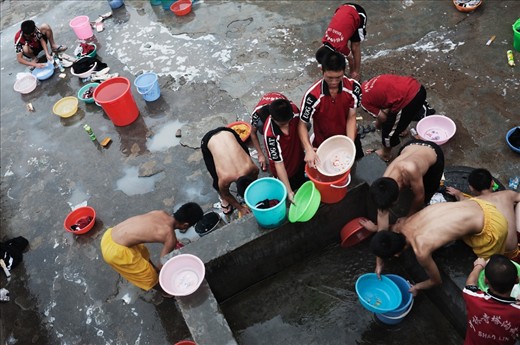 China. Henan province. Dengfeng city. Shaolin Tagou Martial Arts School. Young students washing their tracksuits in the courtyard of the school.