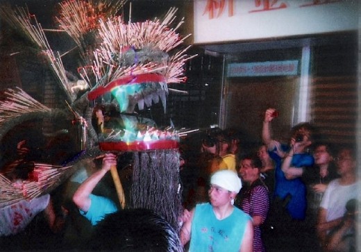 Annual fire dragon festival in Hong Kong where performers carry a 'dragon' constructed by fiery wooden sticks.