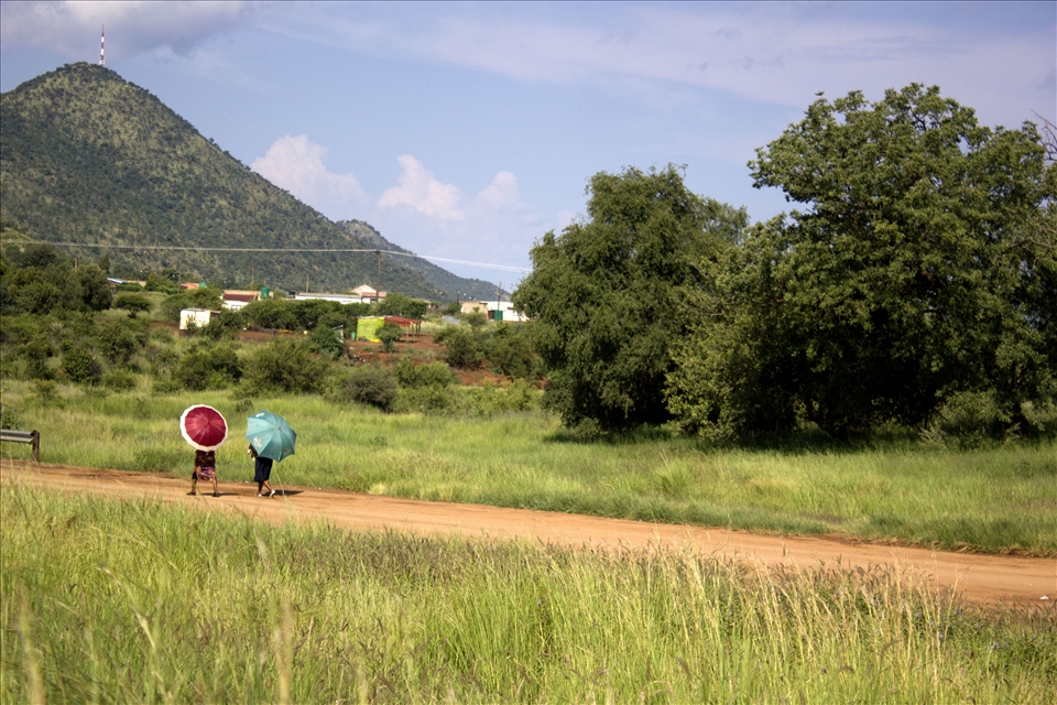 Chatting behind their bright umbrellas, two women wander home