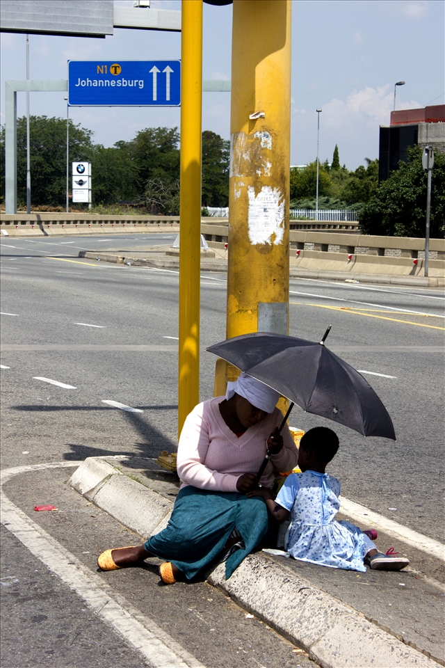 The sun is what ruins her day, the umbrella is what makes it bearable