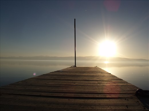 The sun and the old wooden pier on Lake Ohrid. Friends through time.  