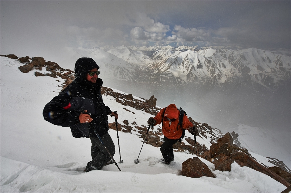 Maxim and Alexander are atop of Peak Sovetov. On our way to the top we've being caught in a blizzard and had to stop, but after a while we saw some clearings and continued our way.
