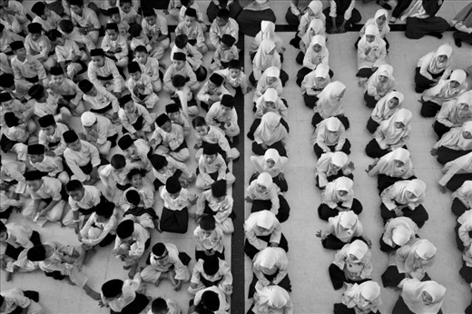Students who attend the school within the National Mosque take part in an assembly. The various roles, expectations, and amounts of freedom in Malaysian Muslim society differ greatly between men and women; these ideas, which are connected to their religion, are fostered from a young age.