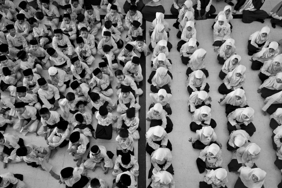 Students who attend the school within the National Mosque take part in an assembly. The various roles, expectations, and amounts of freedom in Malaysian Muslim society differ greatly between men and women; these ideas, which are connected to their religion, are fostered from a young age.