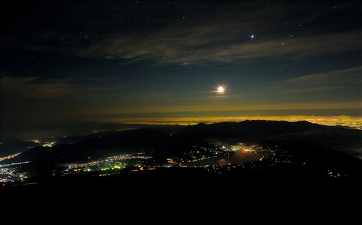 Japanese people start the climb at nightfall to reach the summit for sunrise.  Here, you can see the moon rising over the city of Fujiyoshida.