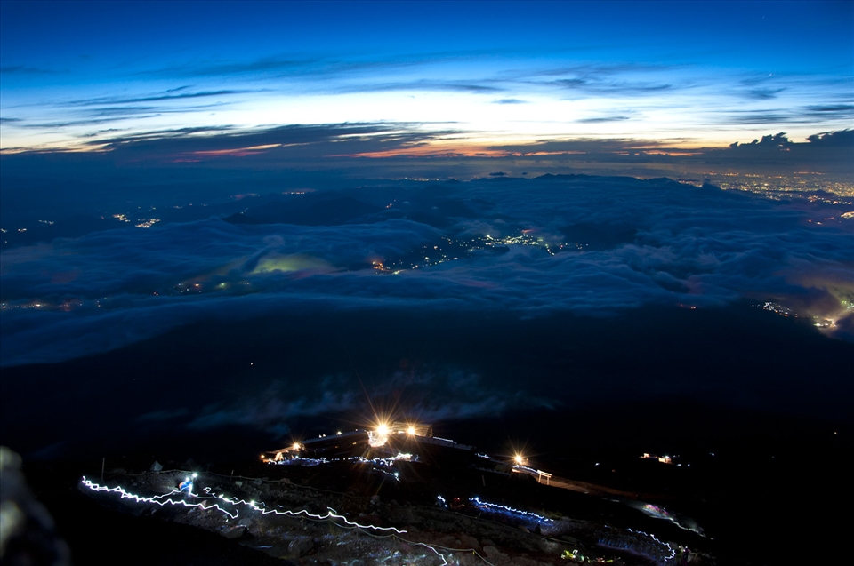About 80 meters to the volcano's crater and the sun is just starting to peak up above a dark hiking trail.