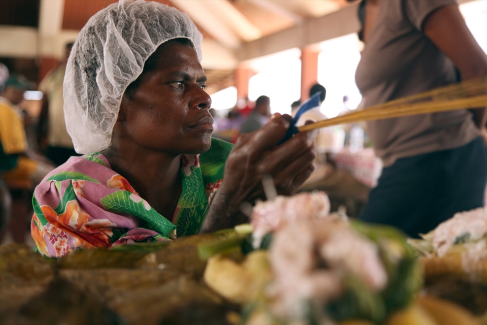 It was very hot, and the flies would be around all the food at all times.This woman keeps them away from her food.
