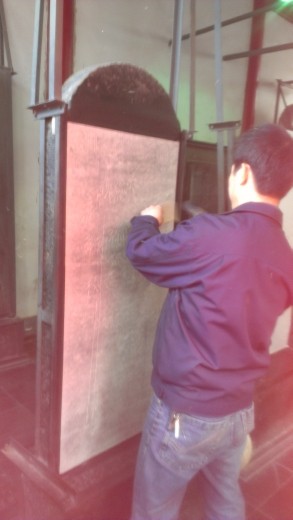 The process of creating stone rubbings - applying the rice paper with water