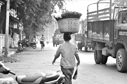 KEEPING BALANCE: A lady effortlessly balancing the load on her head. Products that were not sold on the same day. 