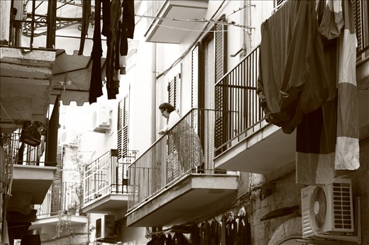 A balcony in the old town becomes the perfect point of view for the theatre of everyday life.