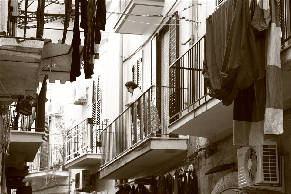 A balcony in the old town becomes the perfect point of view for the theatre of everyday life.